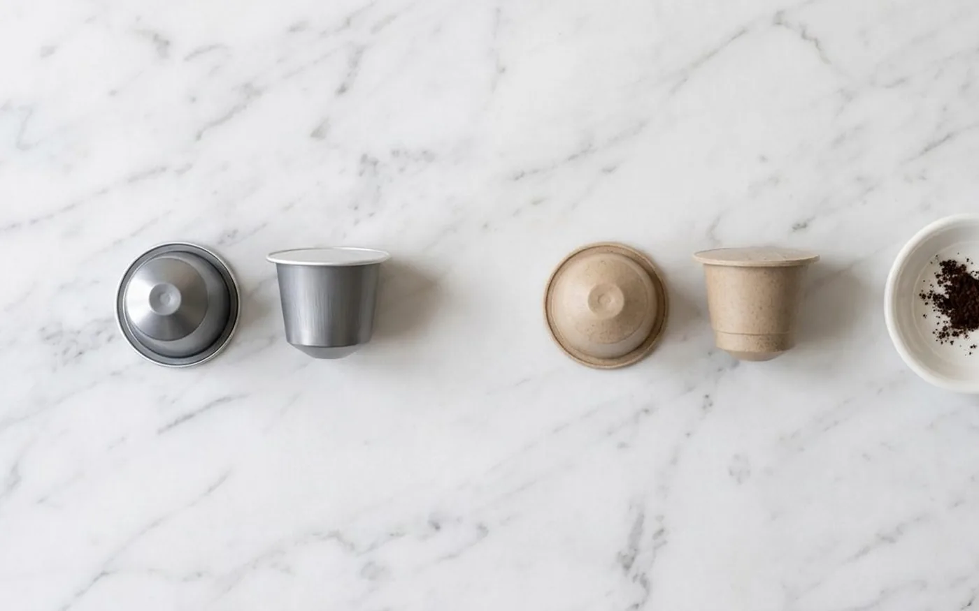 Aluminium coffee pods and compostable coffee pods side by side for environmental comparison