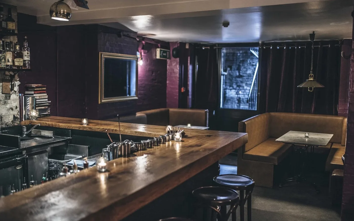 Oak bar top and leather booths in the basement of Happiness Forgets in Hoxton, London