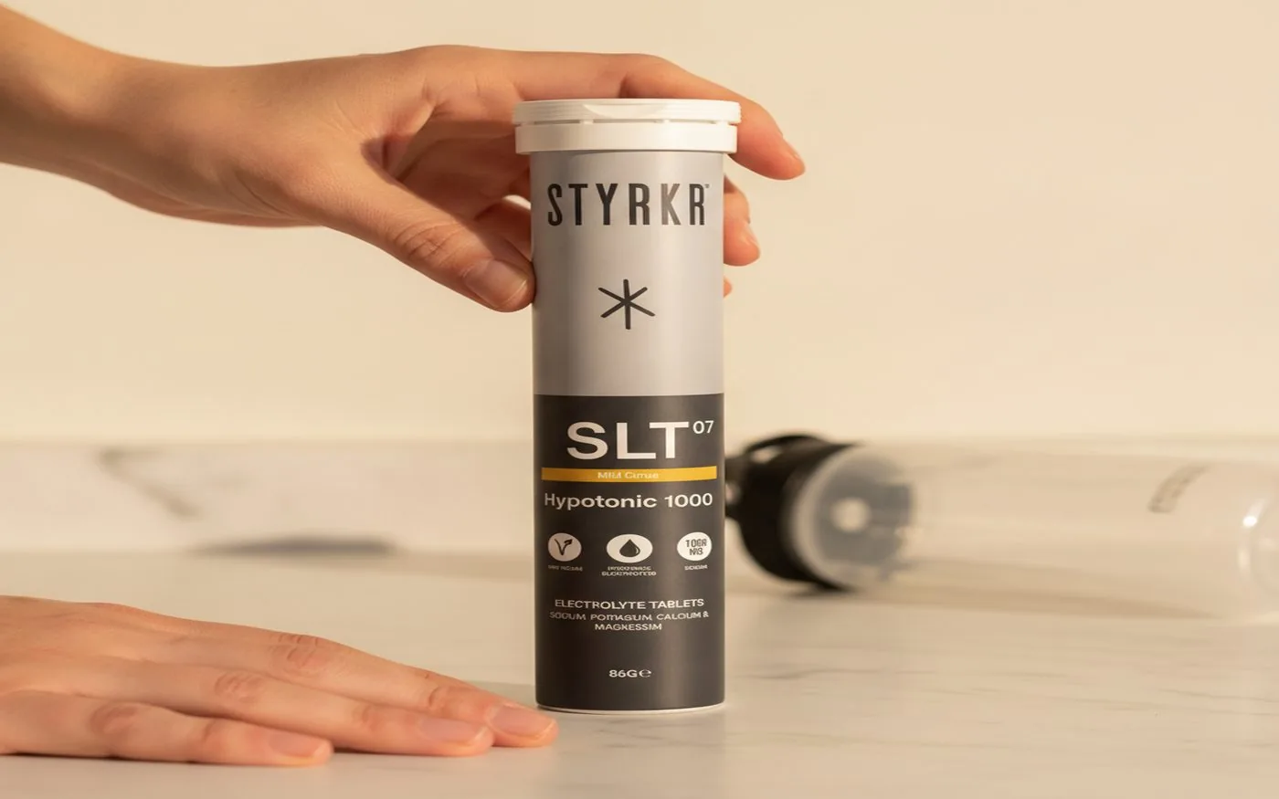 Styrkr SLT07 electrolyte tablets next to a triathlon bike