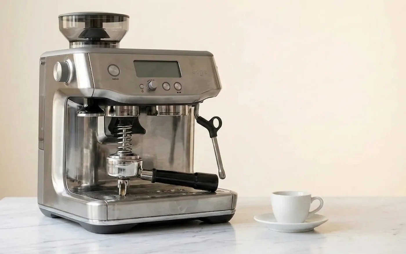 Sage Barista Express Impress espresso machine with integrated grinder and auto-tamping on white marble counter