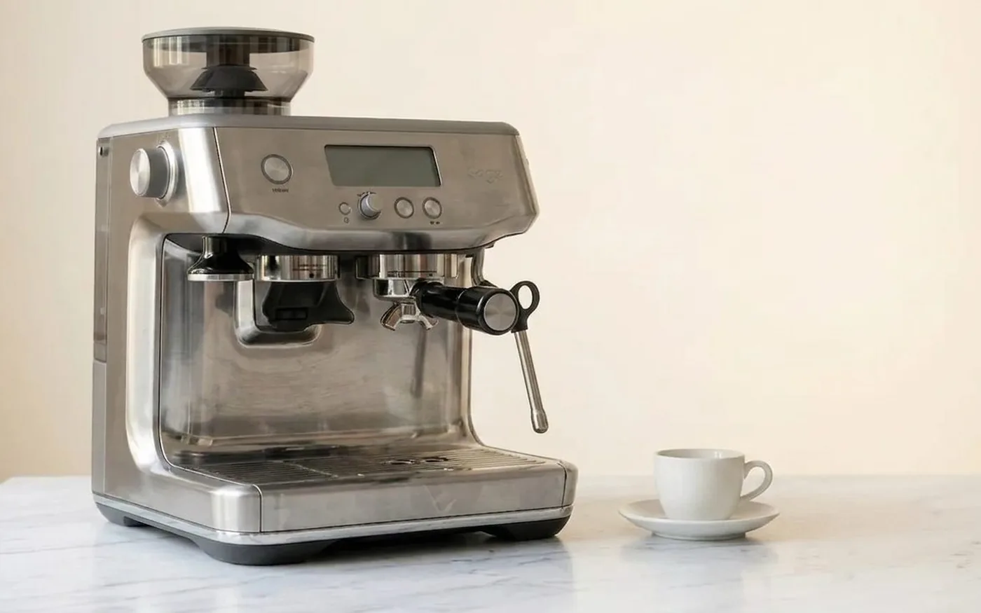 Sage Barista Express espresso machine with integrated conical burr grinder on white marble kitchen counter