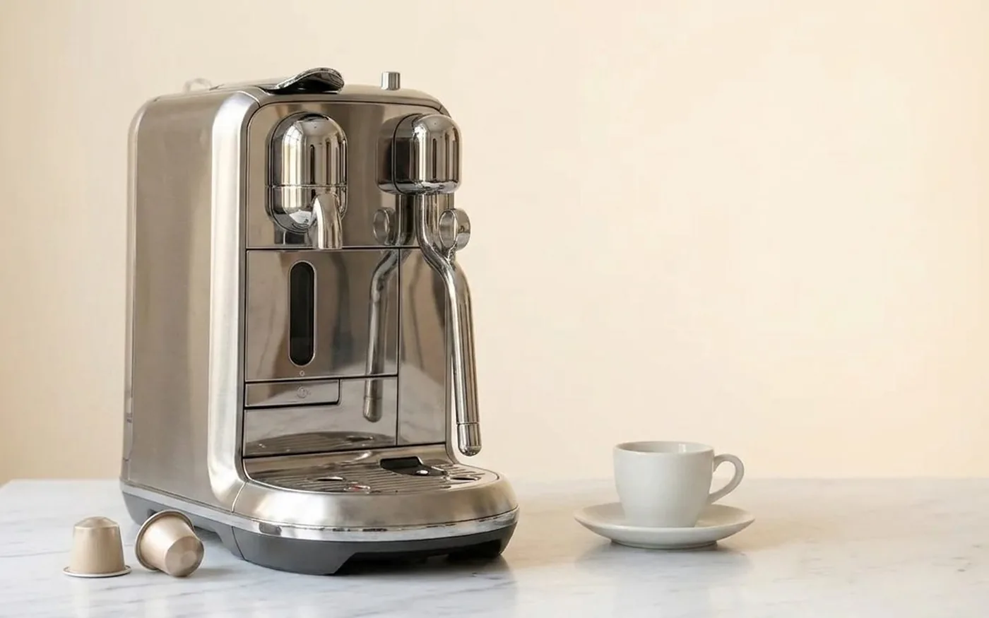 Sage Creatista Plus Nespresso-compatible espresso machine on white marble kitchen counter