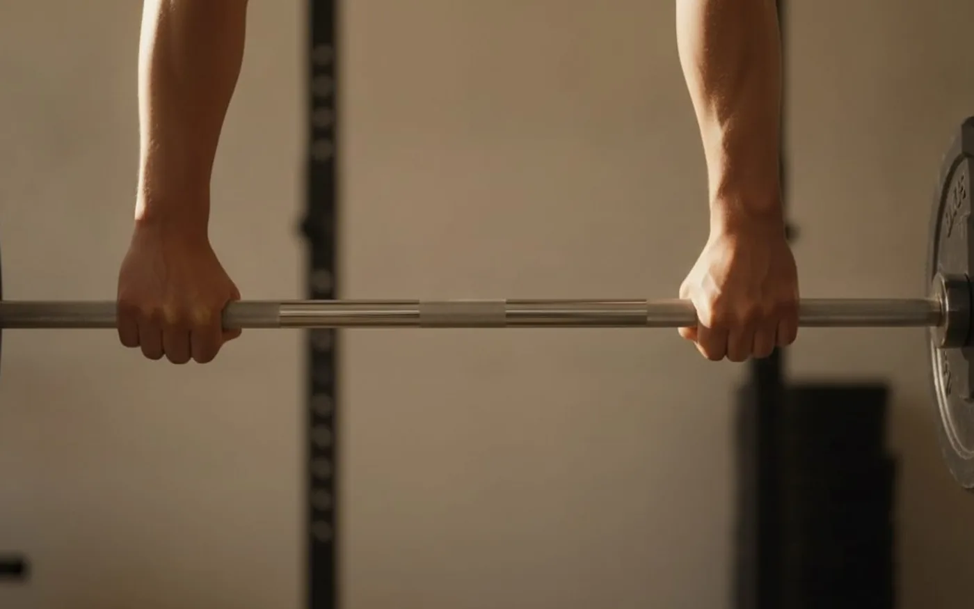 Hands gripping a barbell in the gym, representing the athletic performance benefits of creatine