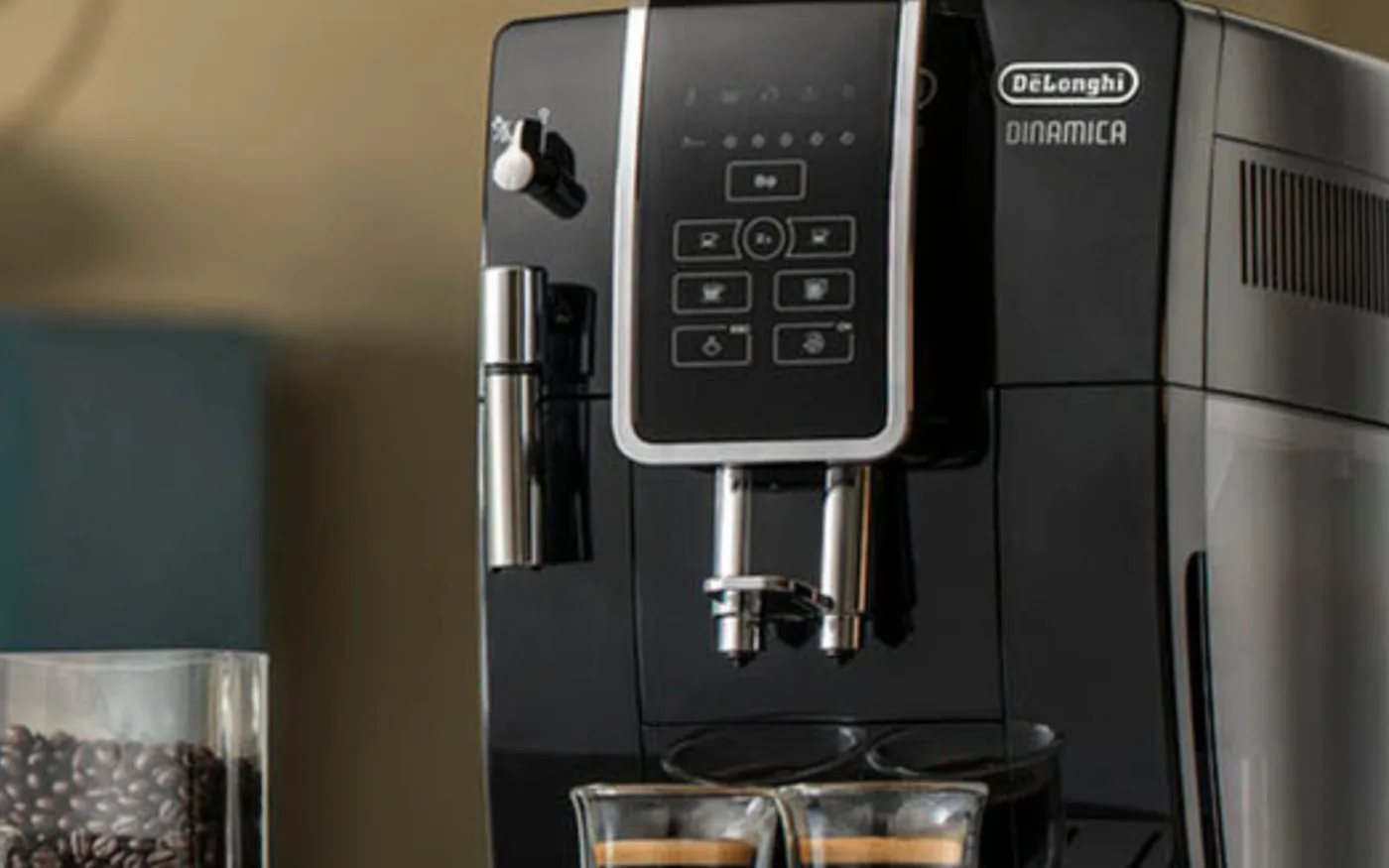 De'Longhi Dinamica bean-to-cup coffee machine on a kitchen counter alongside coffee beans