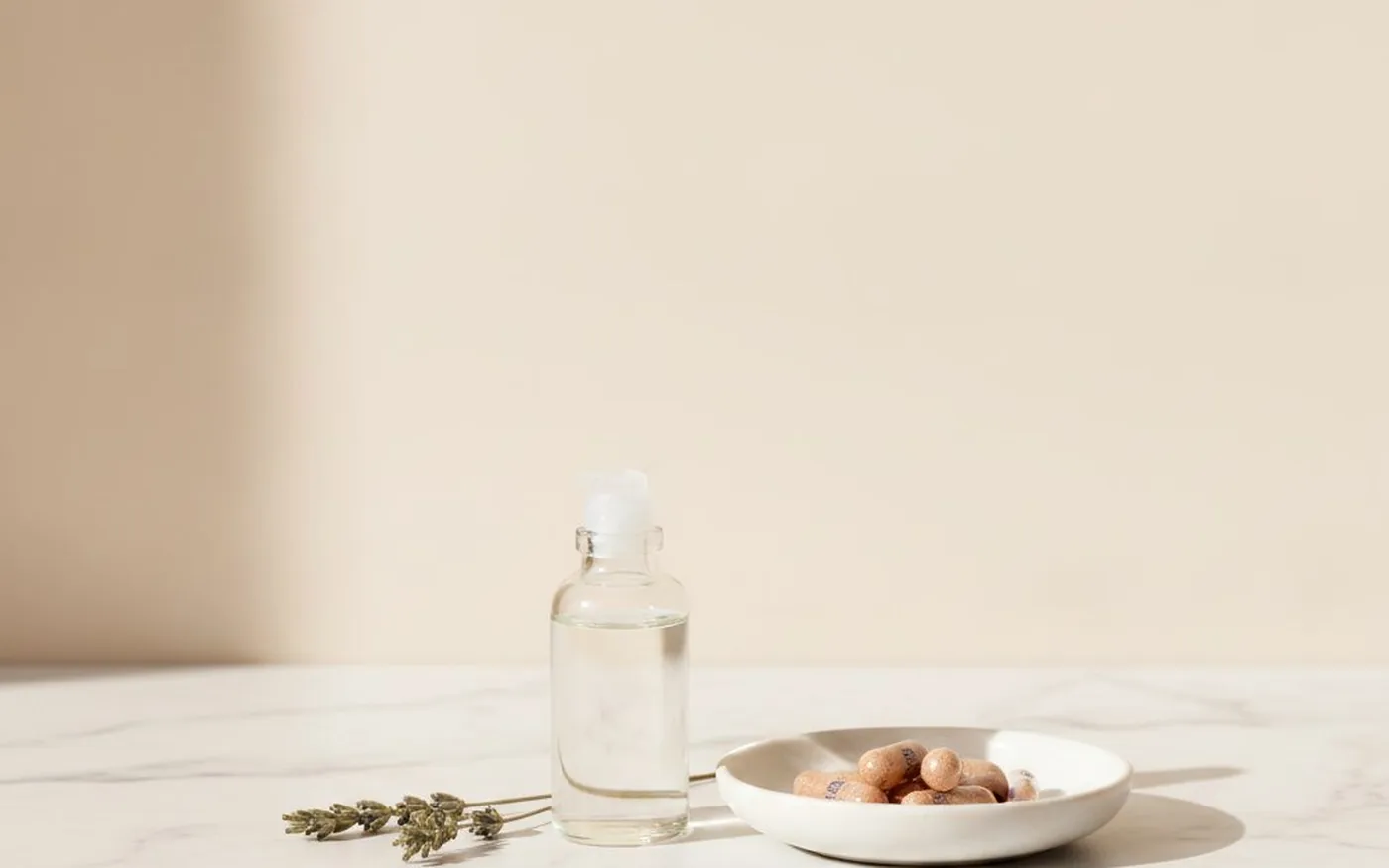 Skincare serum and supplement capsules on white marble - skin health benefits of marine collagen and hyaluronic acid