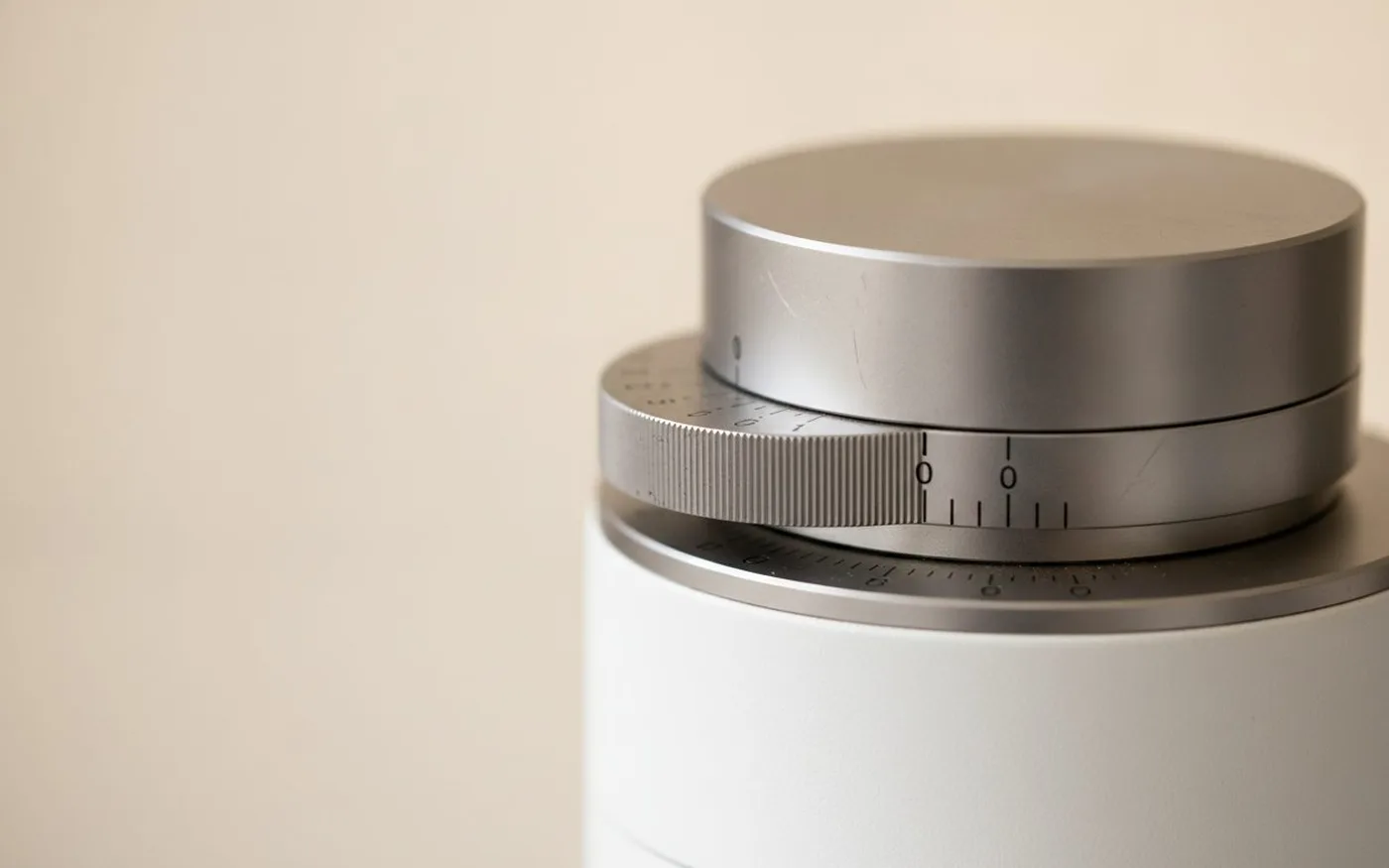 Close-up of coffee grinder stepless collar adjustment mechanism showing precision calibration markings