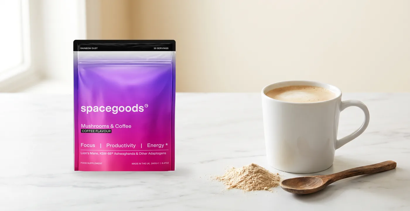Spacegoods Rainbow Dust Mushrooms & Coffee pouch beside a mug and a small pile of powder on a marble counter