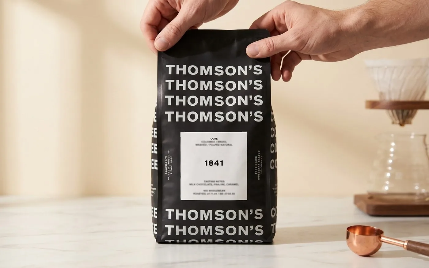Thomson's 1841 house blend 1kg bag with its roast date label, on a dark counter