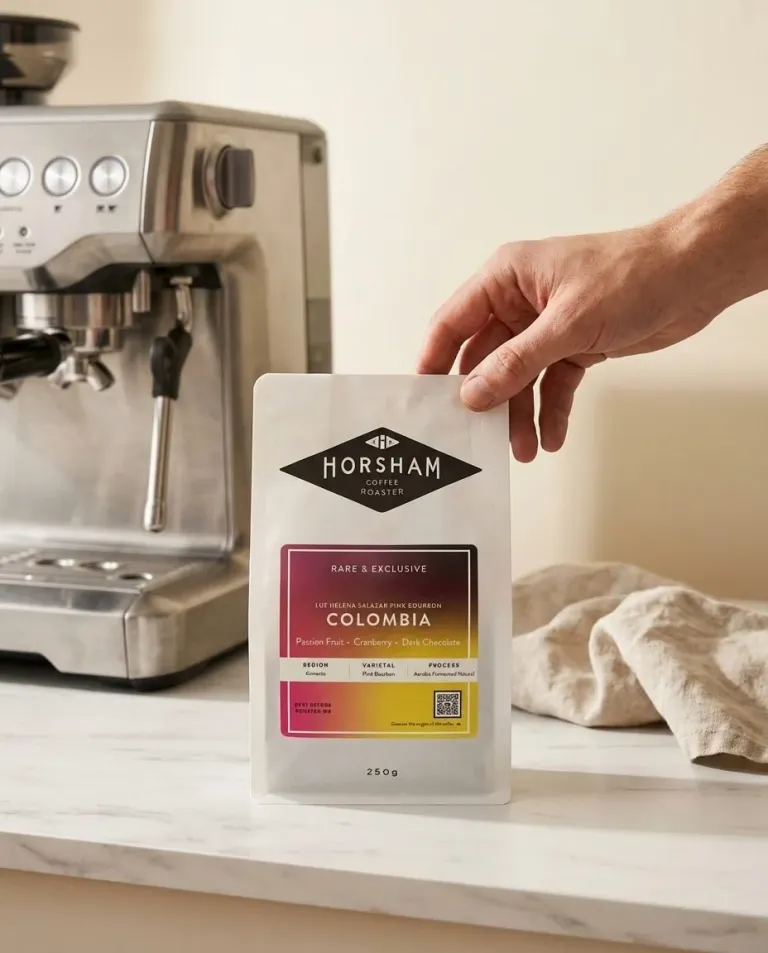 Horsham Coffee Roaster Colombia 250g bag held beside a stainless steel espresso machine