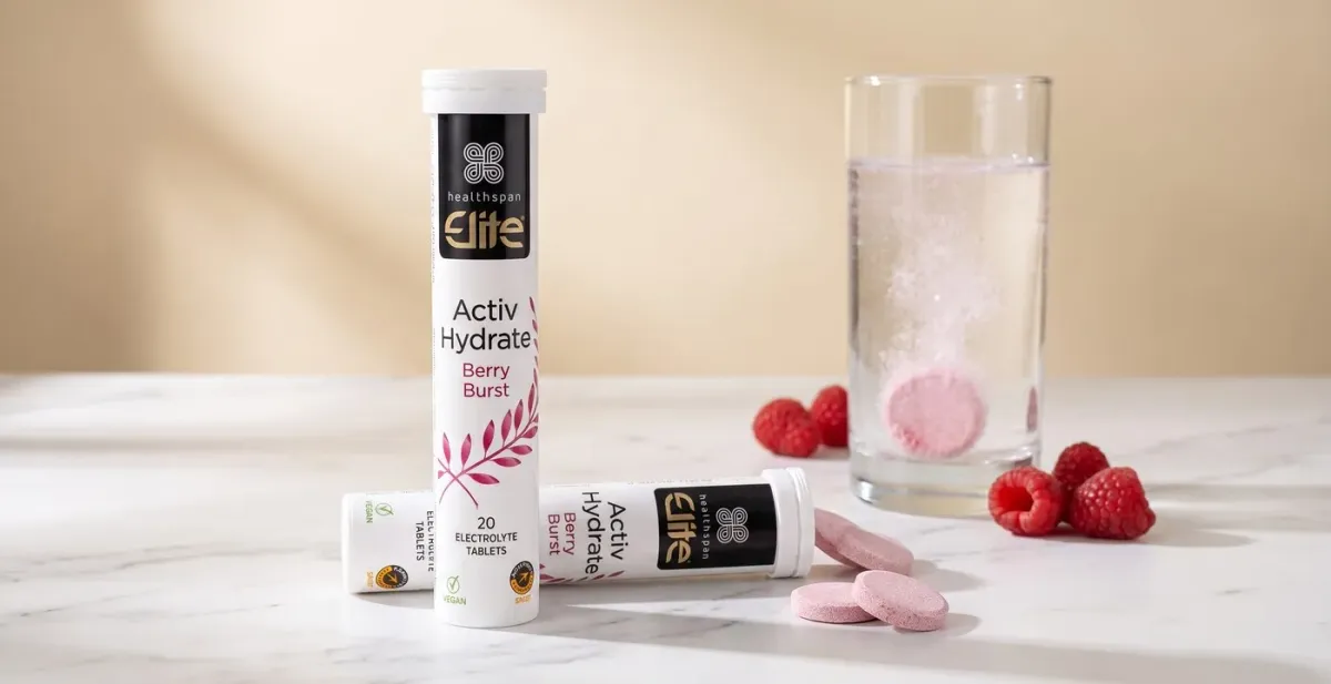 Healthspan Elite Activ Hydrate Berry Burst electrolyte tablets, tubes and a tablet fizzing in a glass of water